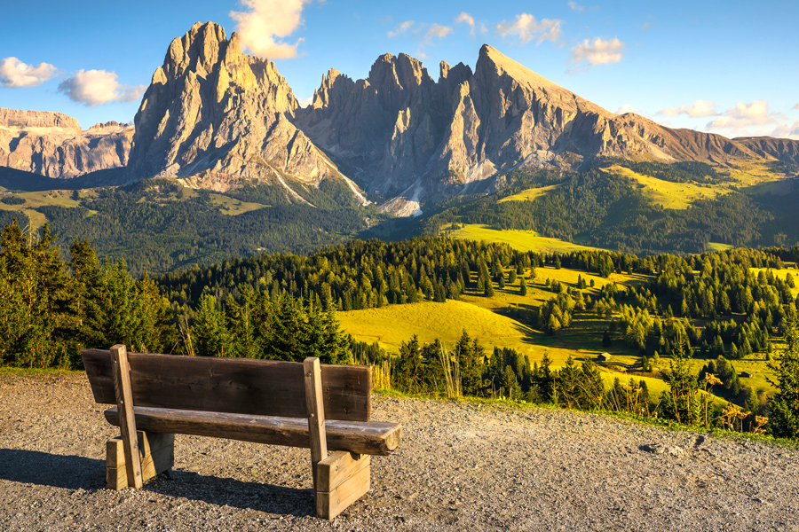 Wanderweg in den Bergen mit Bank und Blick ins Tal